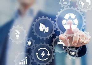Sustainable development concept on screen with icons of renewable energy, natural resources preservation, environment protection inside connected gears, business person in background